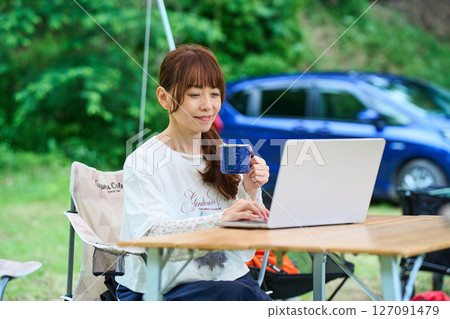 Outdoor barbecue camping senior woman computer Outdoor barbecue camping senior woman computer 127091479