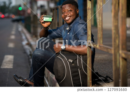 young traveler showing a credit card outside young traveler showing a credit card outside 127091680