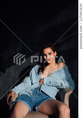 Brunette in off-the-shoulder denim on background Brunette in off-the-shoulder denim on background 127091839