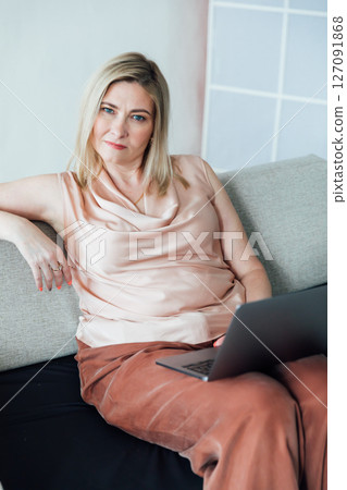 woman working on laptop negotiation online on sofa at home 127091868