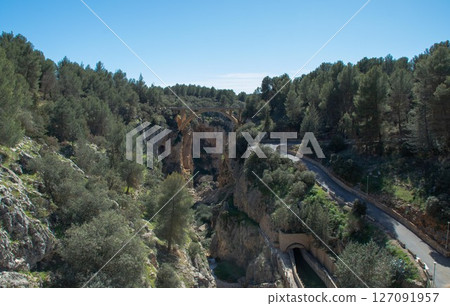 View on the canal exiting La Bolera Reservoir built on the Guadalentin River, near the municipality of Pozo Alcon, in the province of Jaen, Spain. View on the canal exiting La Bolera Reservoir built on the Guadalentin River, near the municipality of Pozo Alcon, in the province of Jaen, Spain. 127091957