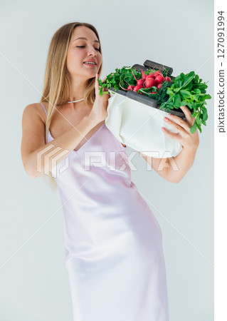 woman holding a bag of green vegetables for diet food and smiling woman holding a bag of green vegetables for diet food and smiling 127091994