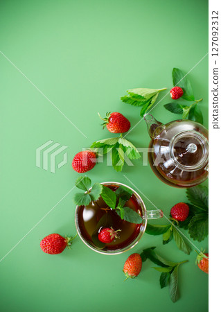 Aromatic herbal drink with berries on a green background Aromatic herbal drink with berries on a green background 127092312