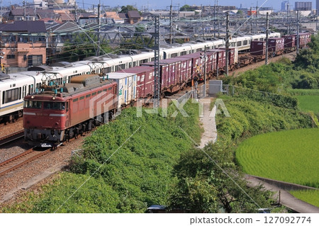 A freight train pulled by EF81-148 runs through the JR Kyoto Line in the scenery of Keihanshin. 127092774