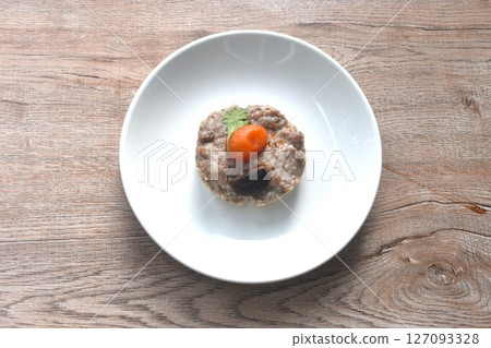 steamed chop pork topping salty egg yolk with black mushroom in gravy sauce on plate 127093328