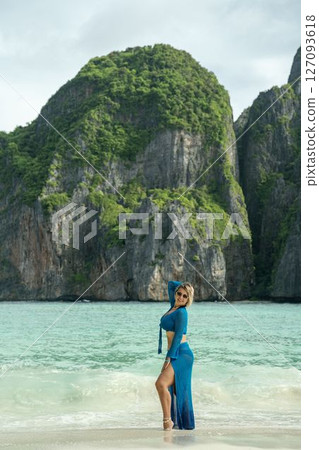 Girl with beautiful figure in blue beach dress on wild green tropical island Girl with beautiful figure in blue beach dress on wild green tropical island 127093618