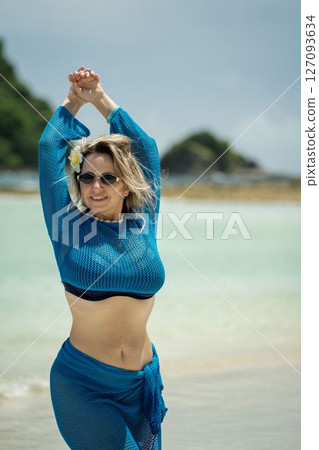 Girl in blue beach dress and sunglasses posing on island 127093634
