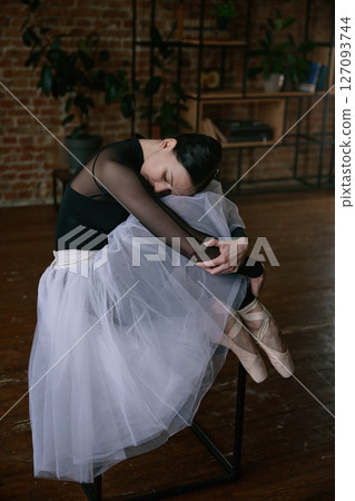 A graceful ballerina in a beautiful tutu practicing her moves in a serene studio setting A graceful ballerina in a beautiful tutu practicing her moves in a serene studio setting 127093744