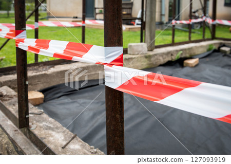 Close-up of Construction Site with Red and White Caution Tape Barrier 127093919