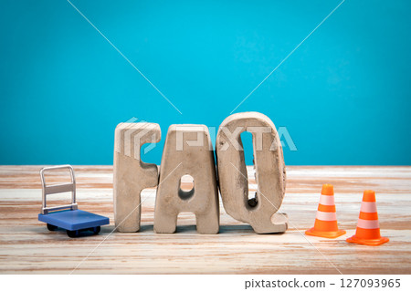 FAQ Concept. Concrete Alphabet Letters on a White Wooden and Blue Background 127093965