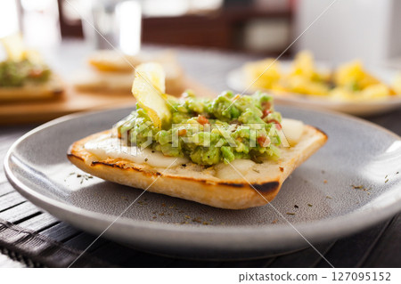 Morning toast with melted cheese and guacamole Morning toast with melted cheese and guacamole 127095152