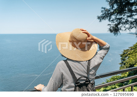 Female Explorer Looking at Ocean Horizon from Cliff 127095690