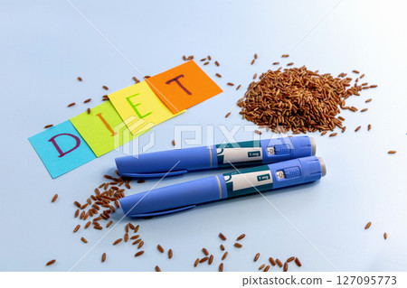Ozempic pen for diabetics and weight loss and diet abbreviation on multi-colored paper and red rice Ozempic pen for diabetics and weight loss and diet abbreviation on multi-colored paper and red rice 127095773