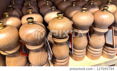 Wooden pepper or saltgrinders on the shelf in the store 127095784