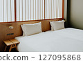 Minimalist Japanese hotel room with twin beds and soft white bedding, shoji screen. Modern ryokan interior  127095868