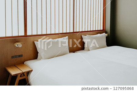 Minimalist Japanese hotel room with twin beds and soft white bedding, shoji screen. Modern ryokan interior Minimalist Japanese hotel room with twin beds and soft white bedding, shoji screen. Modern ryokan interior 127095868