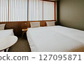 Minimalist Japanese hotel room with twin beds and soft white bedding, shoji screen. Modern ryokan interior  127095871
