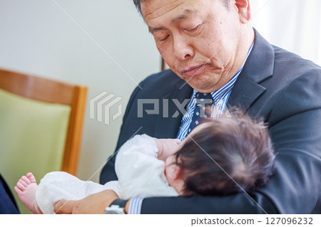Grandfather holding his first grandchild Grandfather holding his first grandchild 127096232