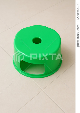Green Plastic Stool on Clean Tile Floor Green Plastic Stool on Clean Tile Floor 127096698