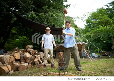 Man chopping firewood at a campsite Camping Outdoor Image 127096729