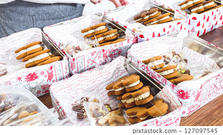 Lovingly homemade gingerbread and sugar cookies, half-dipped in rich chocolate, nestled in decorative Christmas tin boxes perfect for seasonal gifting. 127097545
