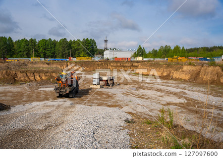 Construction site with heavy machinery preparing foundation for future building. Active phase of groundwork and structural development 127097600