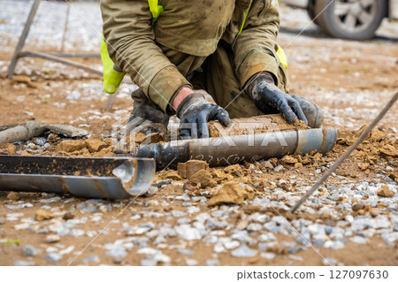 Man cutting and cleaning soil sample for laboratory analysis. Preparation of core material for geotechnical testing and scientific evaluatio 127097630