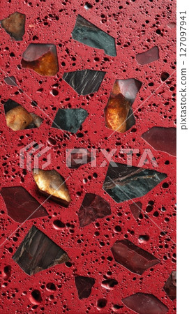 Semiprecious terrazzo surface with red base and gemstone fragments 127097941