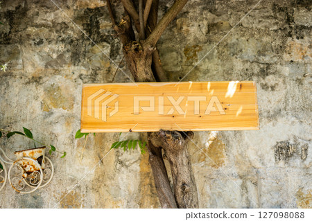 Blank signboard on stone building wall in Mediterranean alley. Concept of urban signage, empty brand space, and local European architecture. Copy space 127098088
