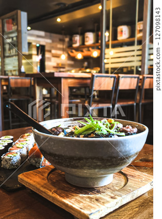 Japanese miso udon noodle soup in bowl on wooden table in a restaurant Japanese miso udon noodle soup in bowl on wooden table in a restaurant 127098143
