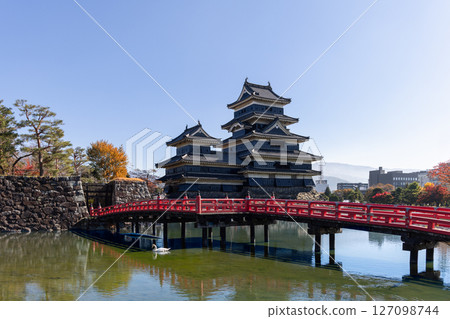 Picturesque autumn view of Matsumoto Castle and red bridge reflected in the moat 127098744