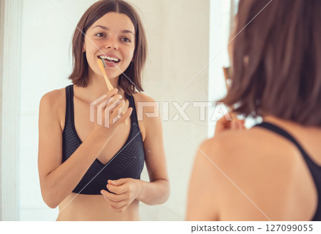Young girl is cleaning her teeth. 127099055
