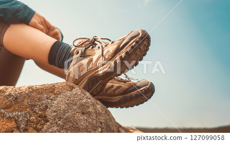 Girl enjoys her journey, sitting on the rock. 127099058