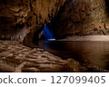 Mysterious Cave Interior with River and Beam of Light 127099405