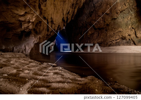 Mysterious Cave Interior with River and Beam of Light 127099405
