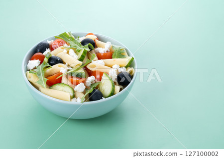 Mediterranean Pasta Salad in bowl with Fresh Vegetables and Herbs 127100002