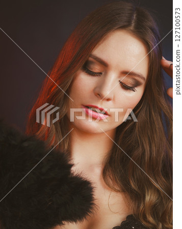 Woman holding carnival feather fan in hand. Woman holding carnival feather fan in hand. 127100573
