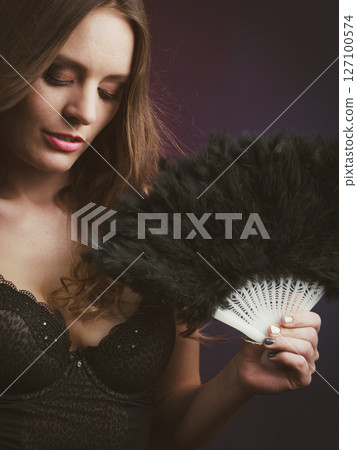 Woman holding carnival feather fan in hand. Woman holding carnival feather fan in hand. 127100574