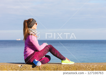Woman resting after doing sports outdoors on cold day 127100763