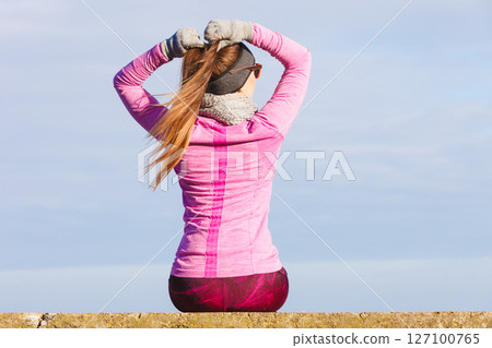 Woman resting after doing sports outdoors on cold day 127100765