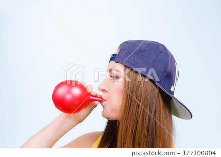 Teen girl blowing red balloon. Teen girl blowing red balloon. 127100804