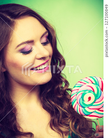 Smiling girl with lollipop candy on green Smiling girl with lollipop candy on green 127100849