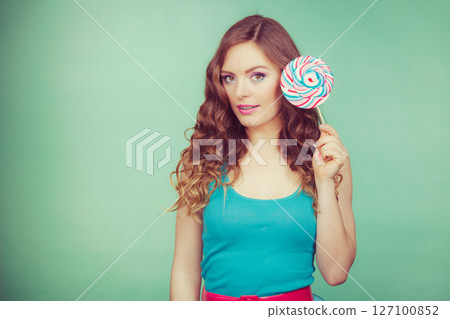 Smiling girl with lollipop candy on teal Smiling girl with lollipop candy on teal 127100852