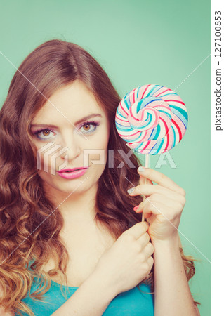 Smiling girl with lollipop candy on teal Smiling girl with lollipop candy on teal 127100853