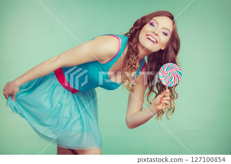Smiling girl with lollipop candy on teal Smiling girl with lollipop candy on teal 127100854