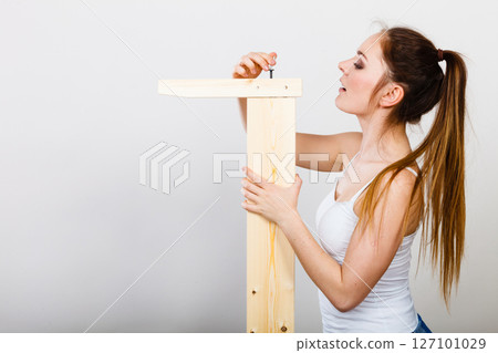 Woman assembling wooden furniture. DIY. 127101029