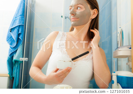 Woman applying mud facial mask Woman applying mud facial mask 127101035
