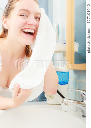 woman washing her face with clean water in bathroom woman washing her face with clean water in bathroom 127101040