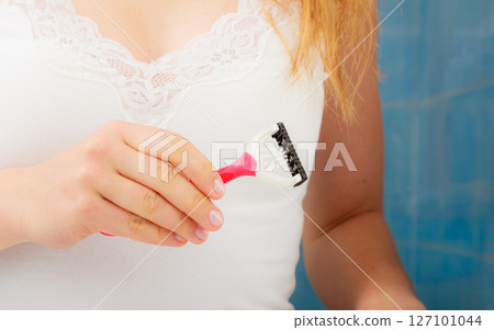 woman holding disposable pink razor blade woman holding disposable pink razor blade 127101044