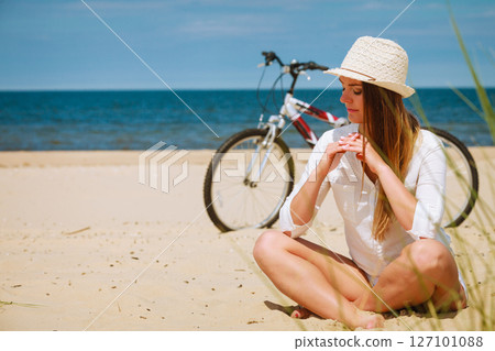 Girl with bike on beach. 127101088